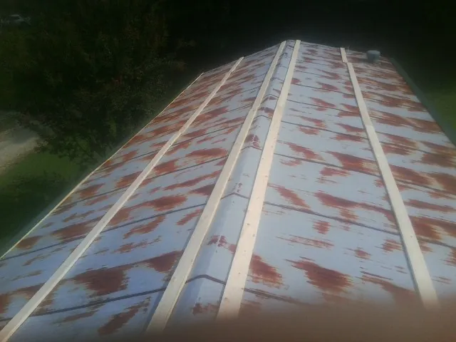 Rusted metal roof panels with new wood purlins before replacement — Storm Damage Roof Repair in Crossnore by Roofing Brothers